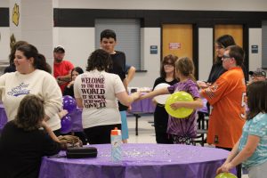 Ariel Snyder (left) and Natalie Wadkins (right of Snyder) pass out the bracelets which will pair buddies up for the year.