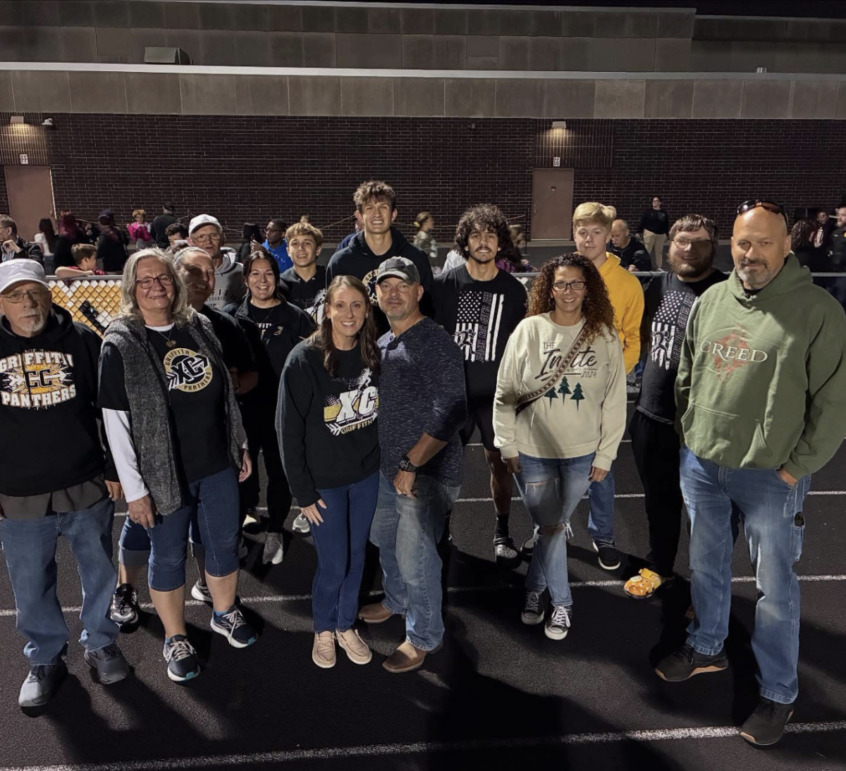 Shannon Brand stands with friends, family and cross-country team members after her final recognition during the football home opener on Aug. 29. 