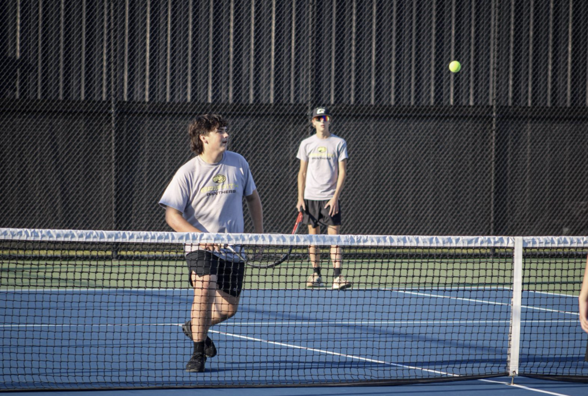 Junior Tyler Drozd (left) lines up for a return with his doubles partner Senior Victor Scortino (right).