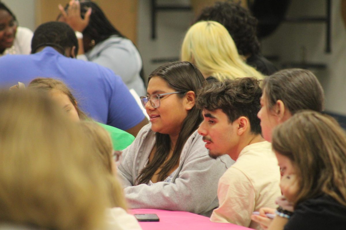 Amilia Torres and (I FORGOT HIS NAME) sit and chat with other members.