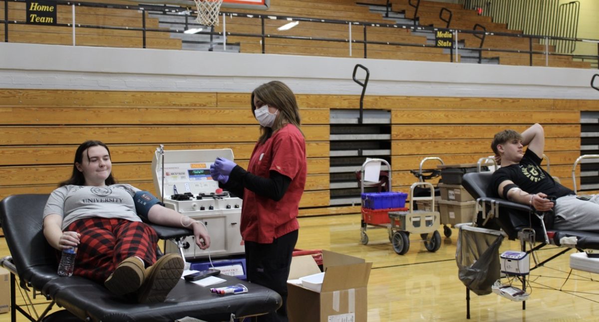 Senior Emma Kidd and junior Stanley Lesko donate blood on Feb. 6 in the main gym.