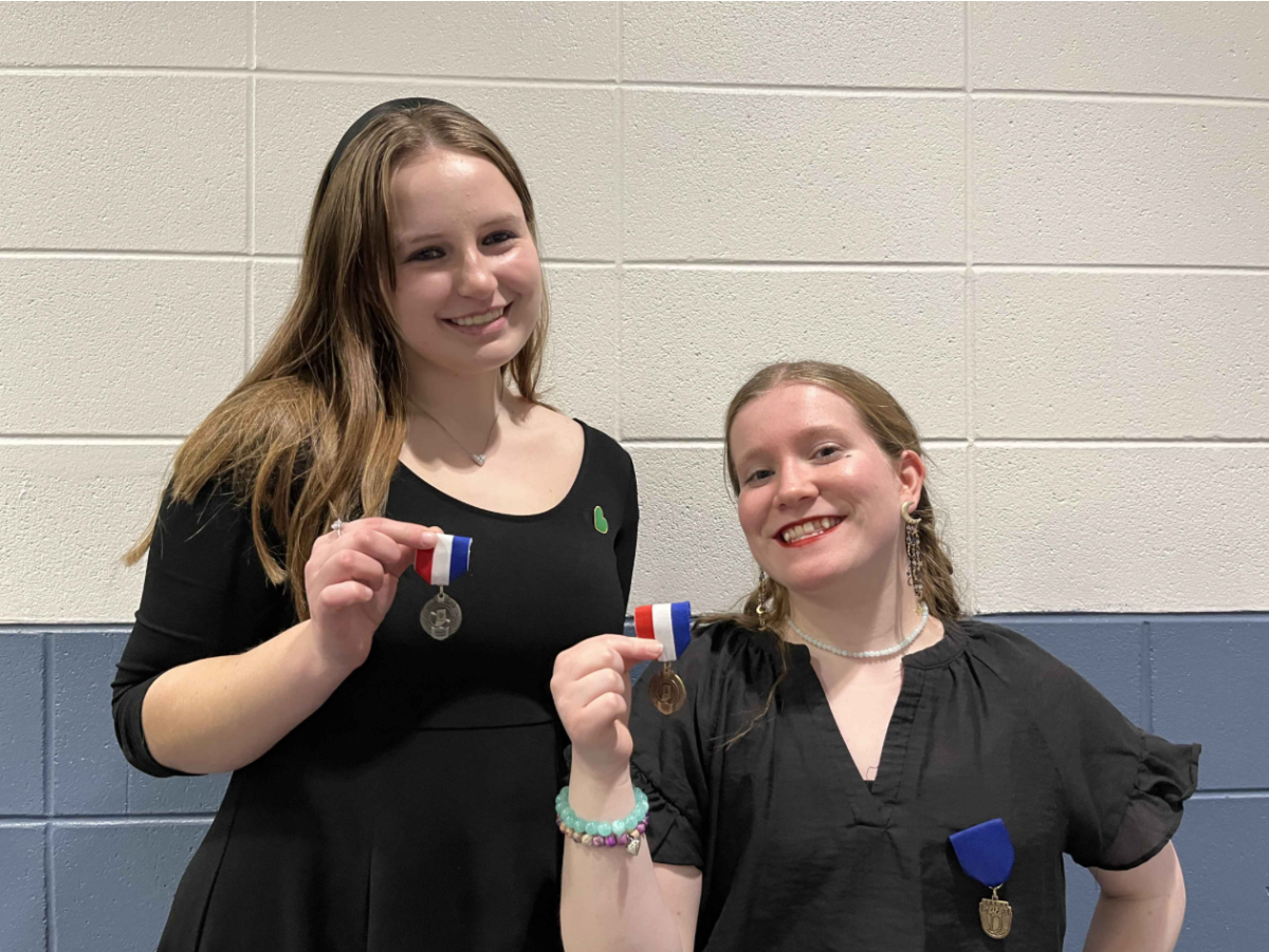  Juniors Jeanne Pressler and Mya Munsie hold up their medals from state on February 21. Pressler and Munsie both attempted group 1 solos for the first time this year.