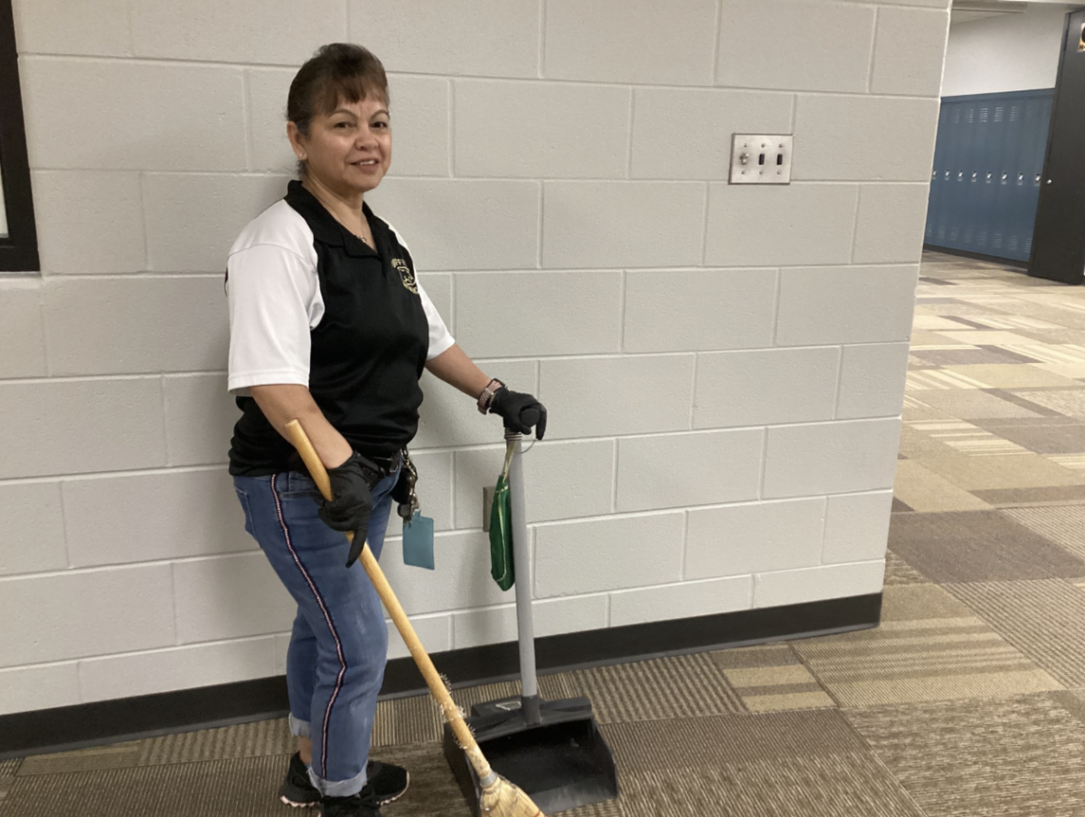 Custodian Georgina Hernandez waits for the hallways to clear during a passing period to end at Griffith High School. She just finished cleaning a stairwell and was waiting for students to go to lunch/advisory.