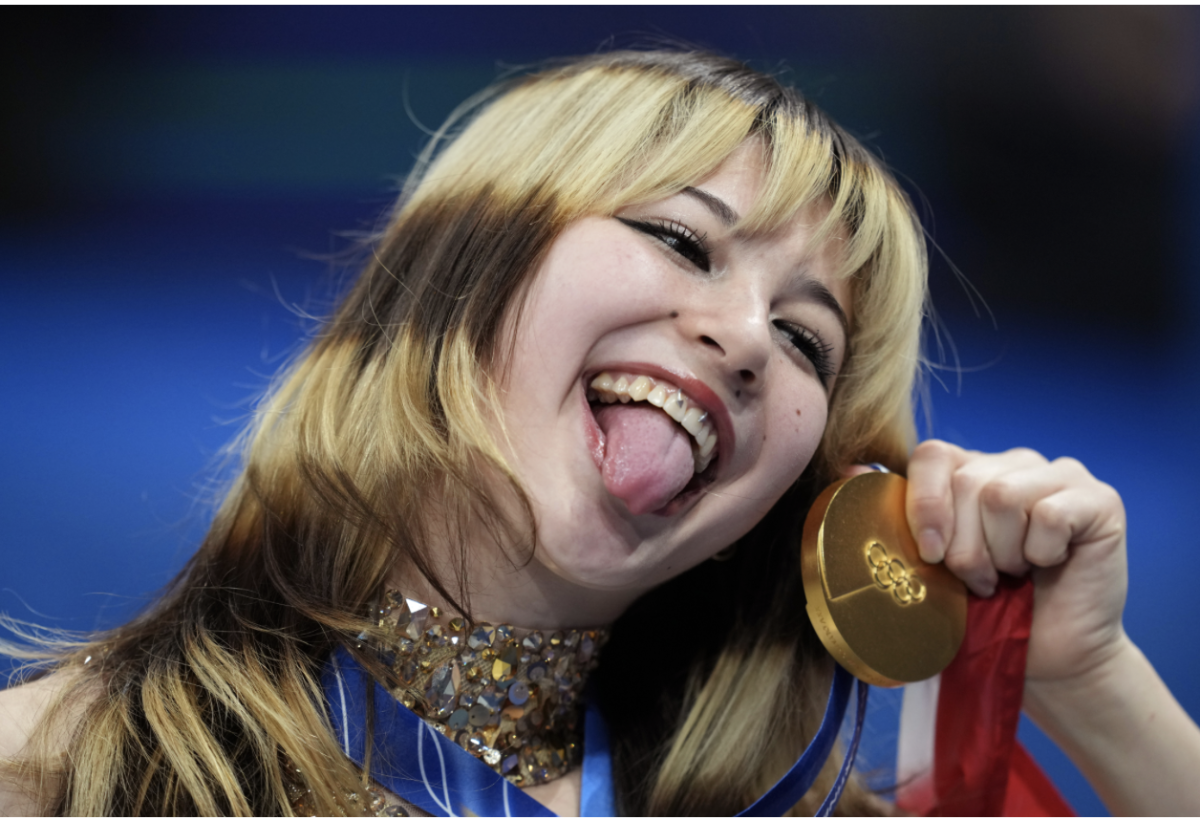 Former female Olympic figure skater, Alysa Liu, poses in front of camera, celebrating her win at the 2026 Winter Olympics that took place in Milan, Italy. Liu won for her outstanding performance in women's freestyle figure skating.