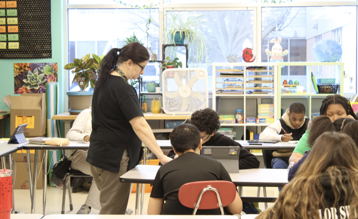 Mrs. Randi Vianello assists a student with math in a self-contained special education classroom.