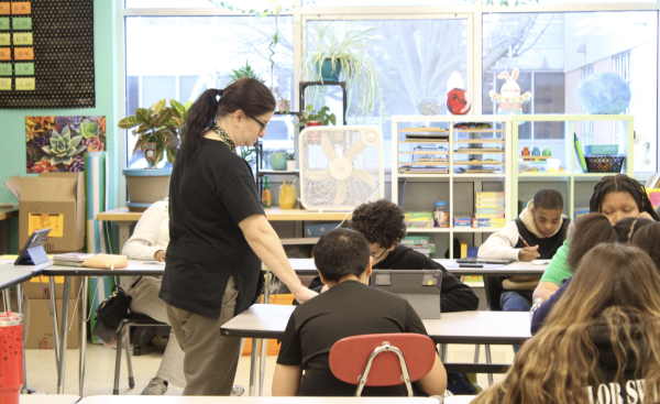 Mrs. Randi Vianello assists a student with math in a self-contained special education classroom.